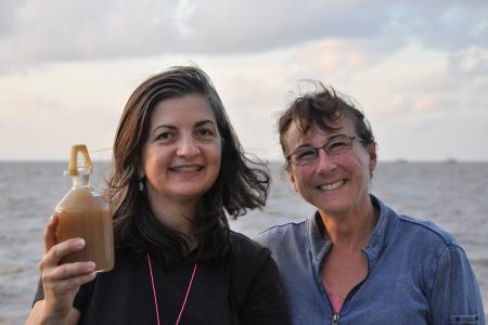 Patricia Yager, holding bottle of seawater next to Debbie Landrum
