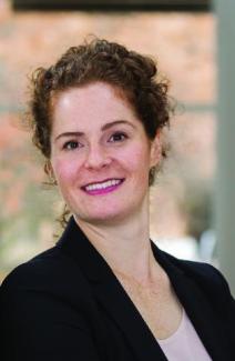 Dr. Jill McDermont smiles into the camera in a black blazer and pink shirt