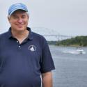 Dr. Glen Gawarkiewicz smiles at the camera in a light blue ball cap and a navy polo